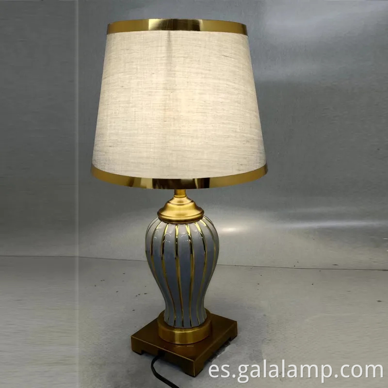 Elegante lámpara de mesa de cerámica con base de metal dorado para el dormitorio